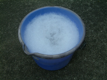 バケツの中でカーシャンプーと水を混ぜて泡立てる