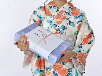 お中元を手に持つ女性